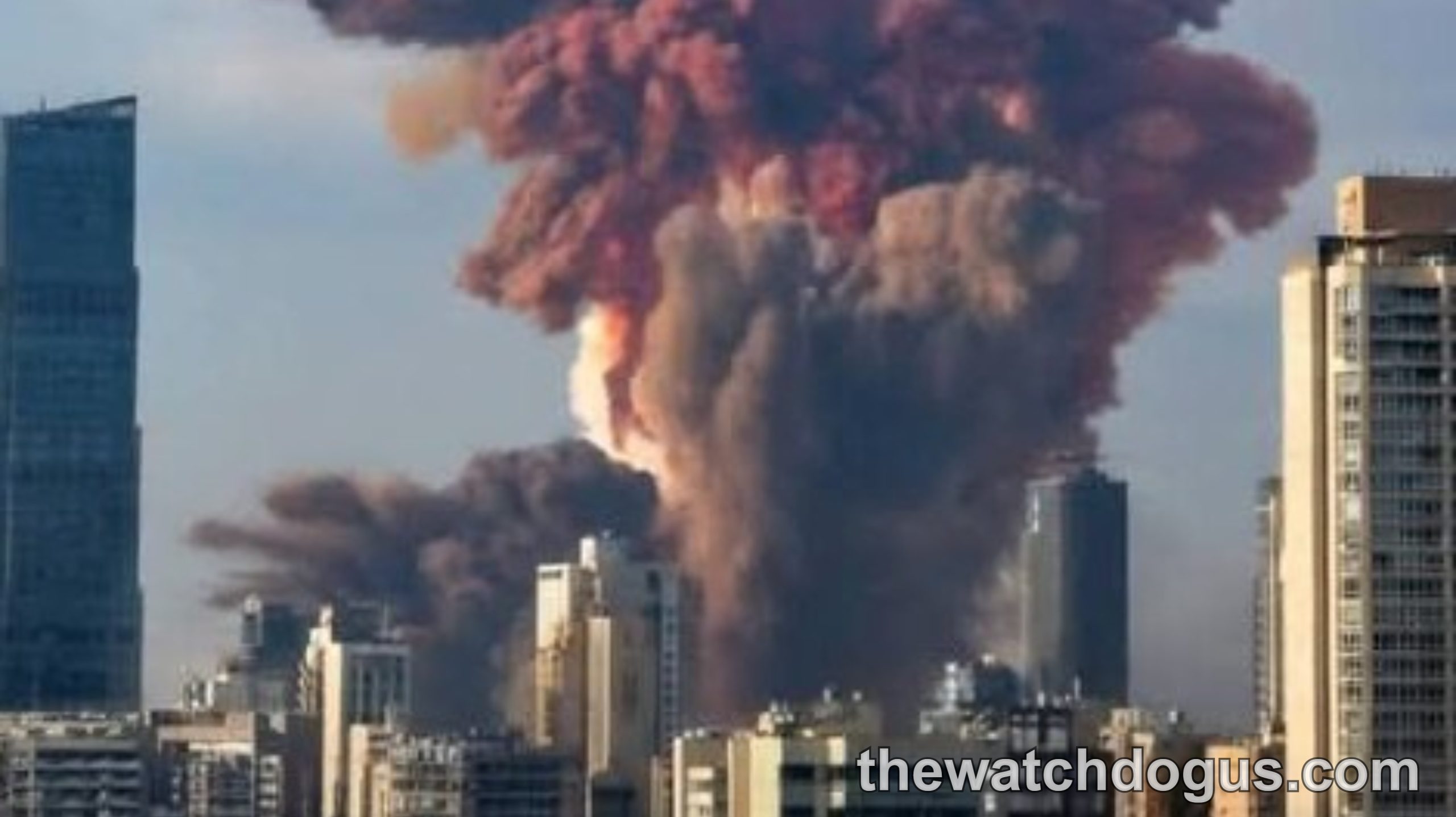 Large explosion with red and orange smoke rising above city skyline during Israel operation