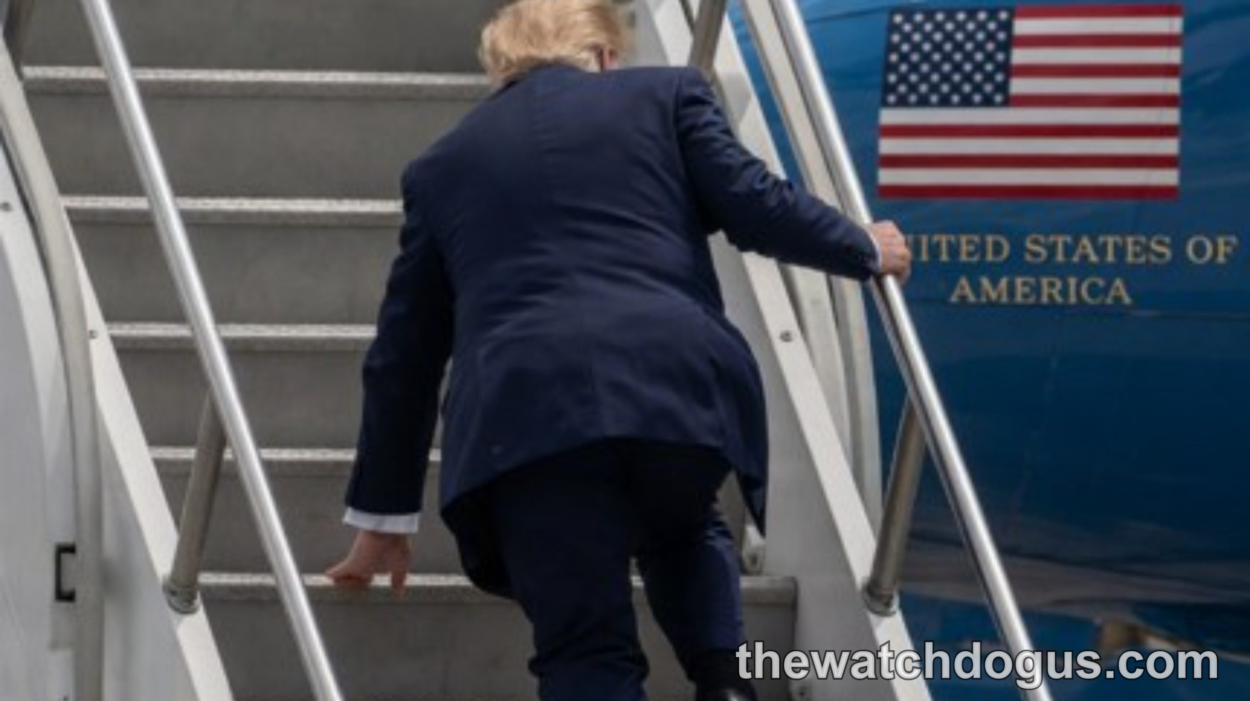 Man in dark suit climbing stairs to Trump Air Force One aircraft with American flag visible