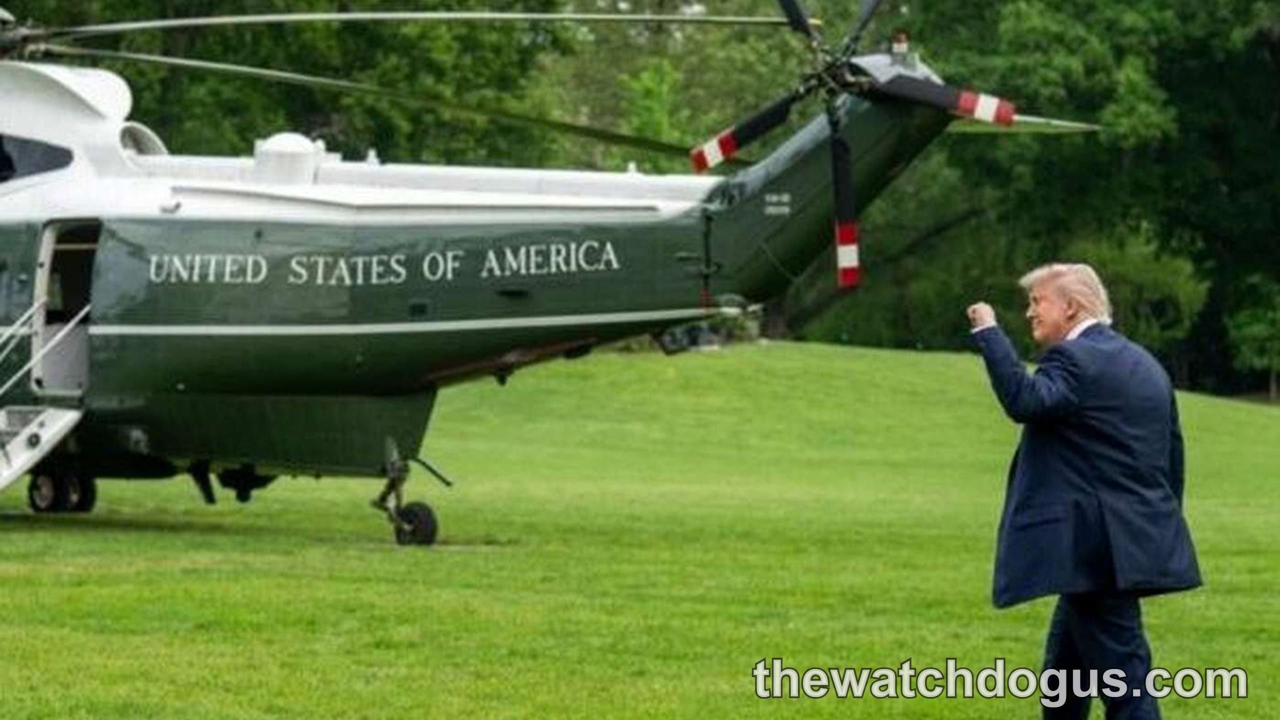 Trump Marine One photo shows man in navy suit waving at presidential helicopter on lawn with green trees background