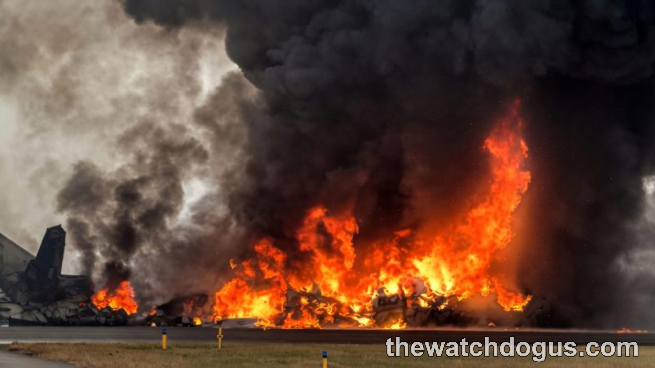 Massive fire and smoke from plane crash wreckage on airport runway with emergency response