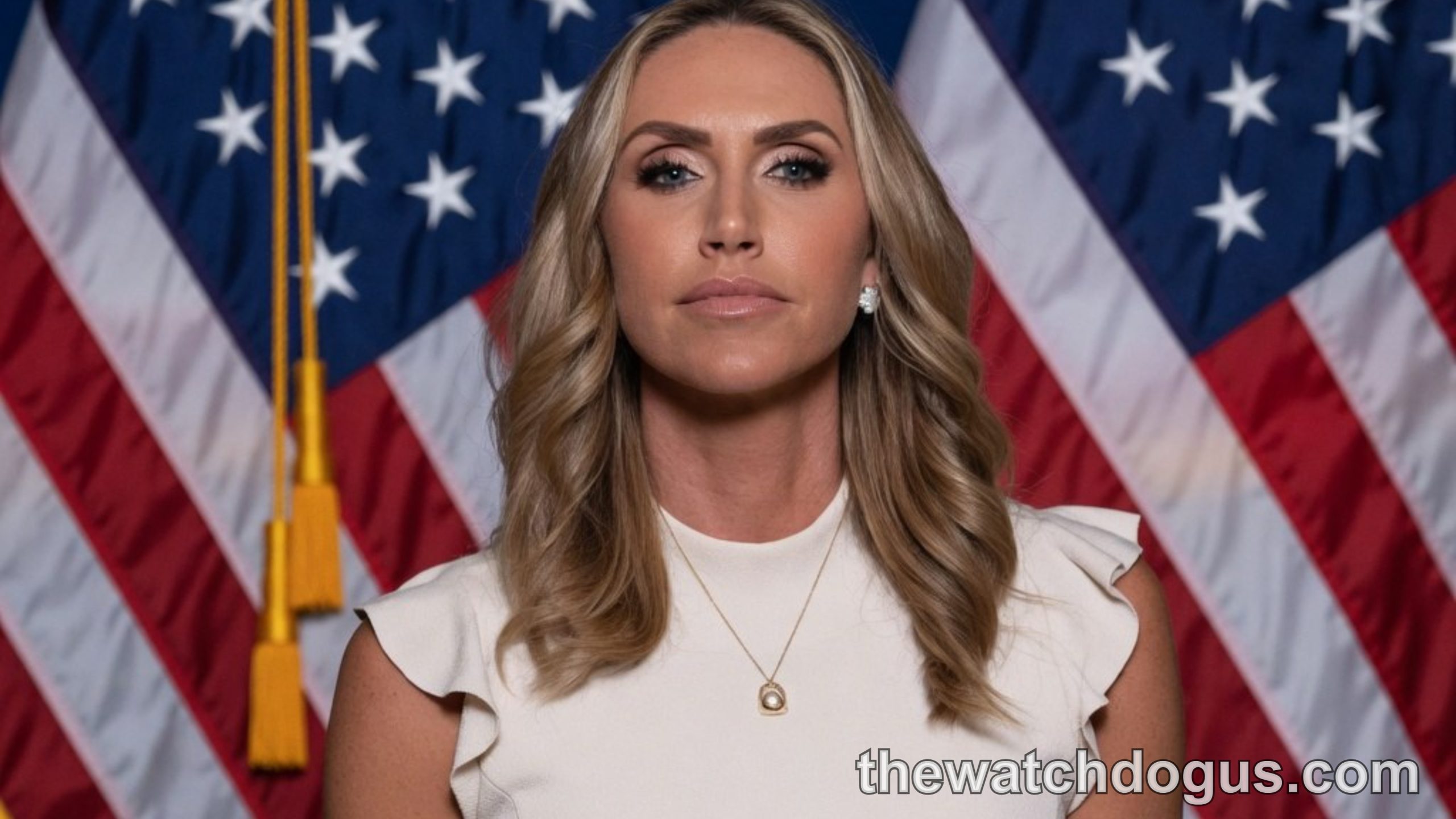 Lara Trump RNC co-chair portrait with American flags background in professional white and black attire