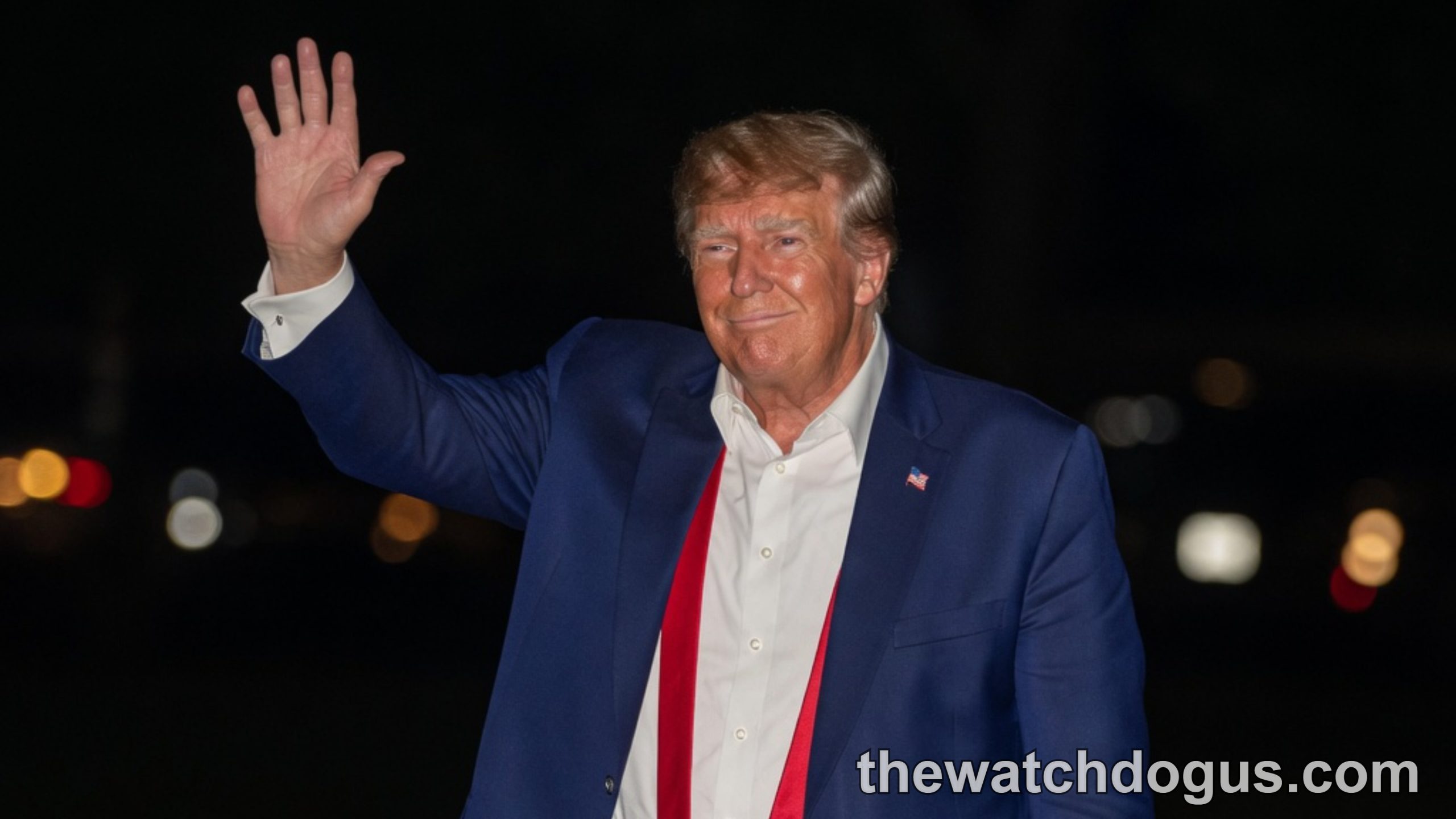Man in blue suit waving at political photo interpretation event wearing red tie