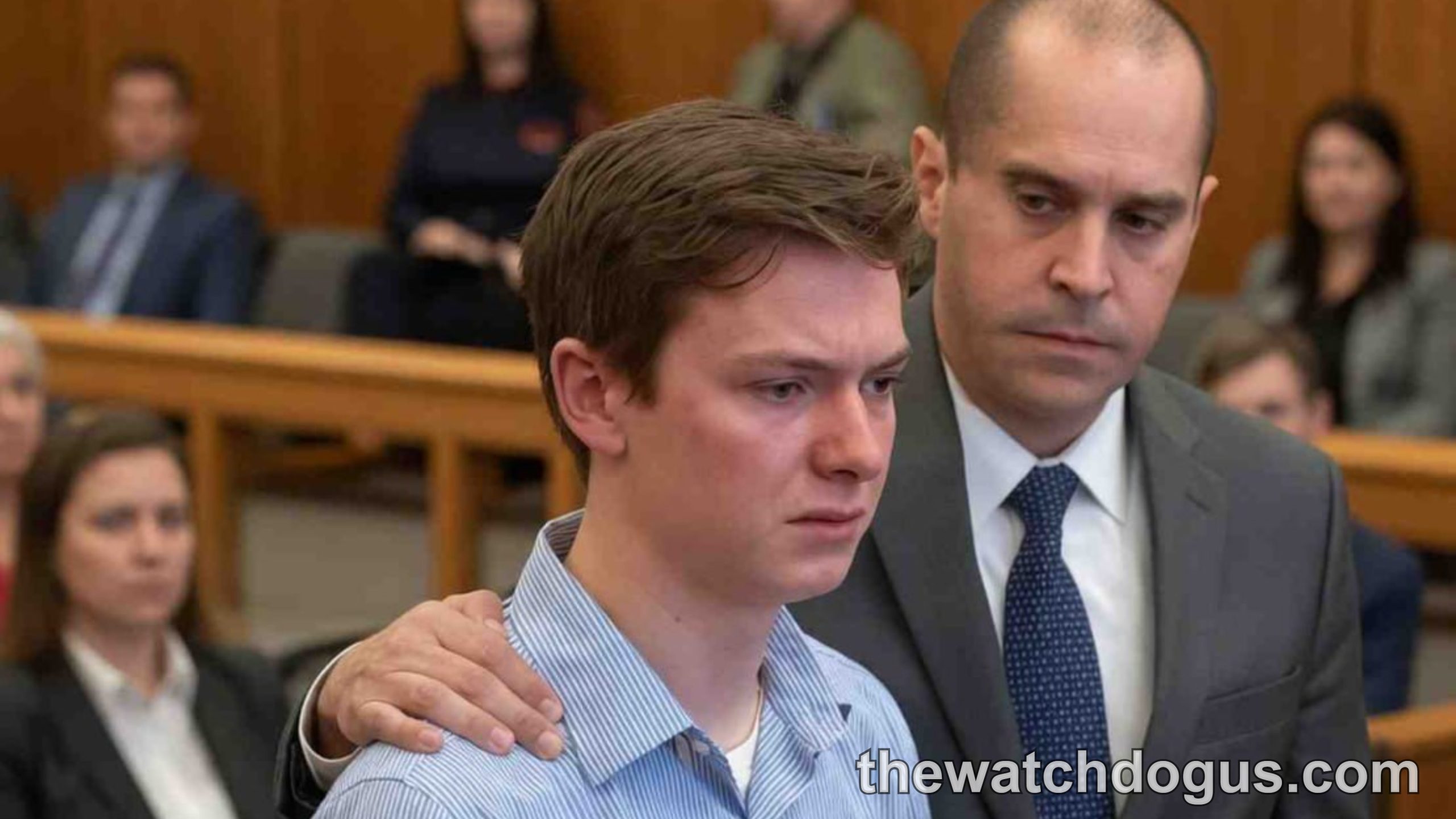Young teen in blue shirt stands with attorney in courtroom, illustrating teen justice consequences and legal representation