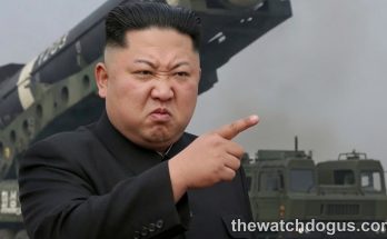 North Korea military leader makes statement gesture with missile launch display in background