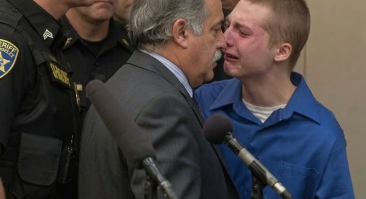 Young man in blue shirt with gray-haired man in suit during juvenile sentencing hearing with sheriff officers present