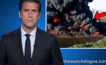 News anchor reporting on national tragedy response with aerial footage of large industrial fire and emergency response