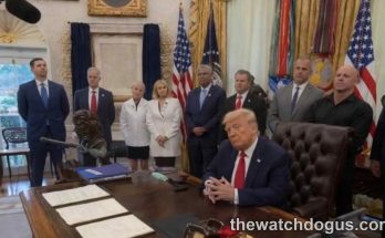 Judge resigns Trump administration official seated at Oval Office desk with staff members standing in background