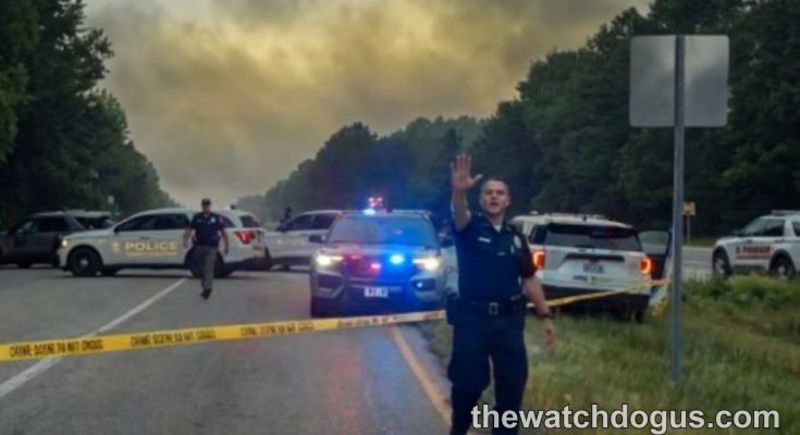 Police officers conducting a major highway security operation with emergency vehicles and crime scene tape during police operation security response