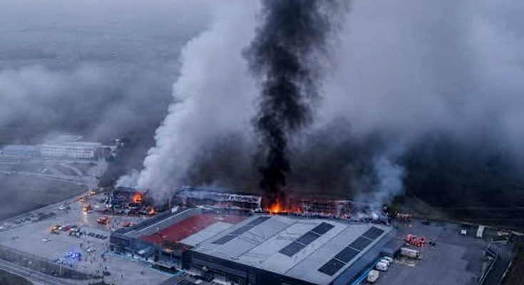 Aerial view of Greece factory fire with massive smoke plume rising from industrial building with solar panels